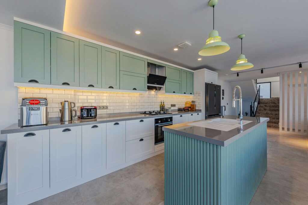 A Kitchen with Green Cabinets and White countertops